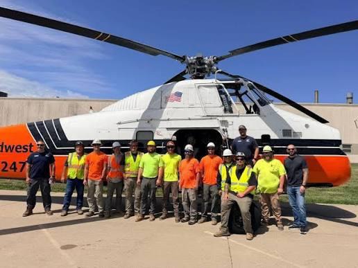 team in front of a helicopter